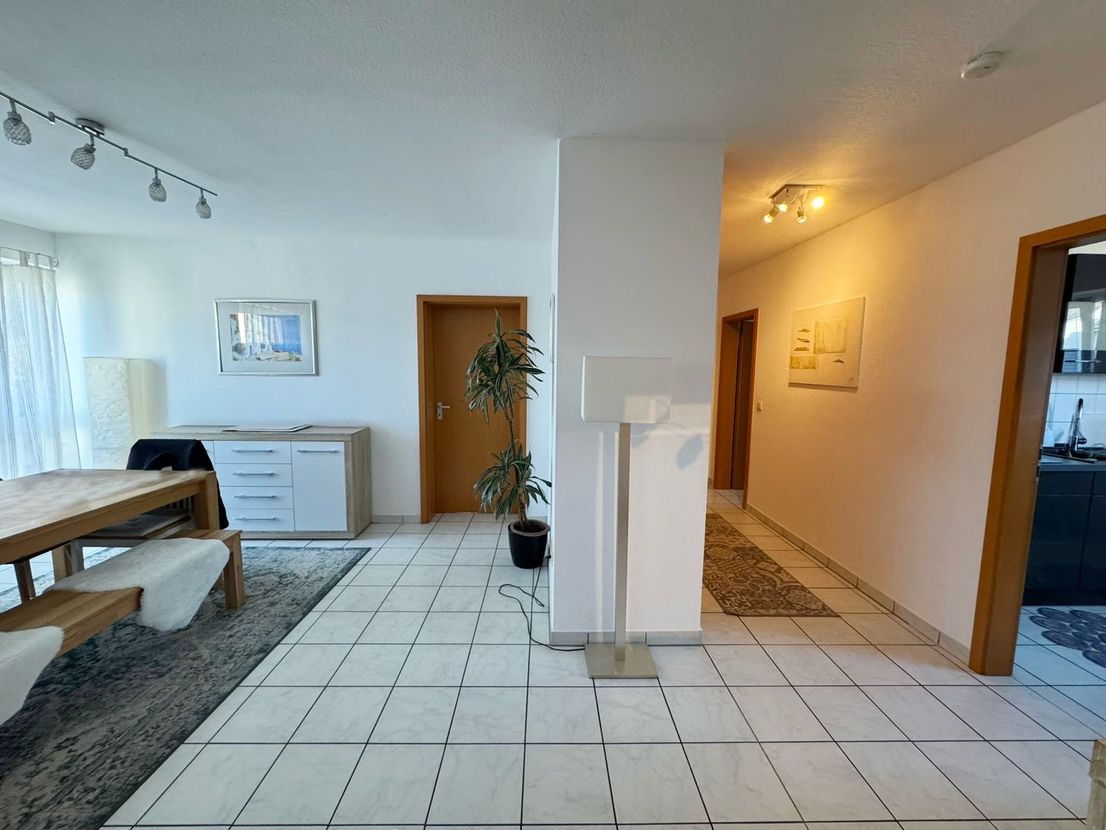 Offener Wohn- und Essbereich mit Blick in den angrenzenden Flur der Wohnung